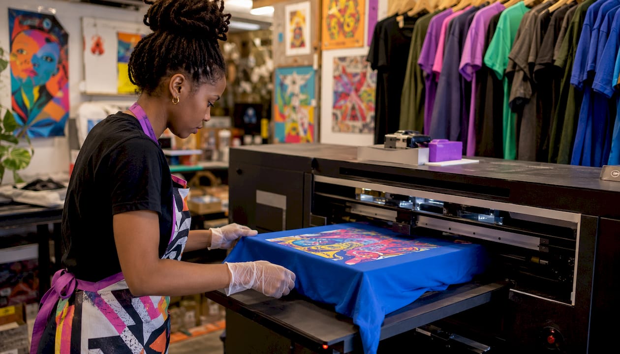 Technician operating DTG printer with shirt