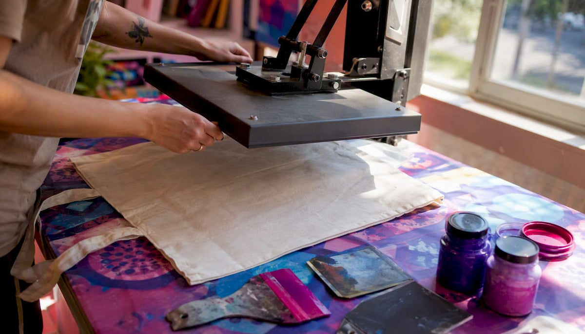Hands aligning heat press on tote bag